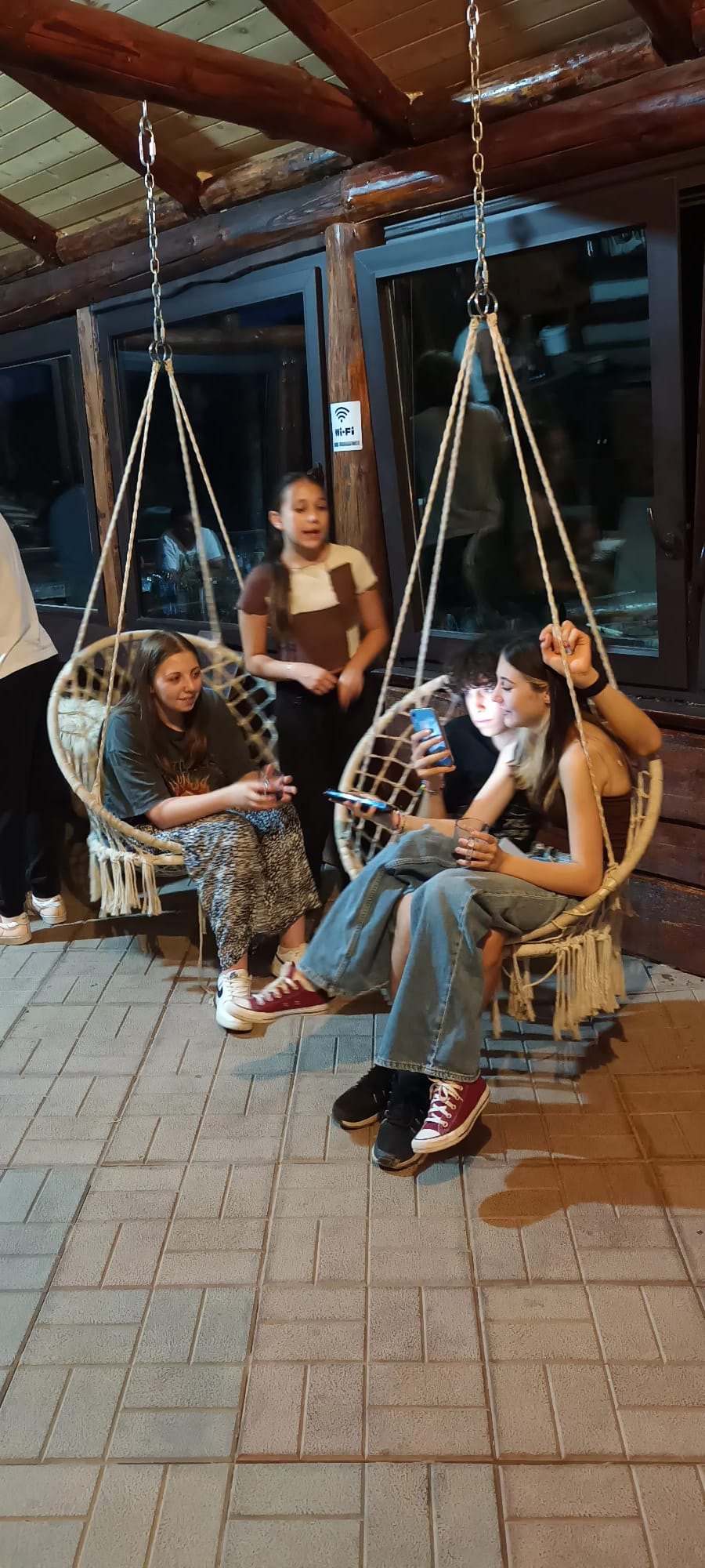 Young people in the swing chairs on the guesthouse terrace