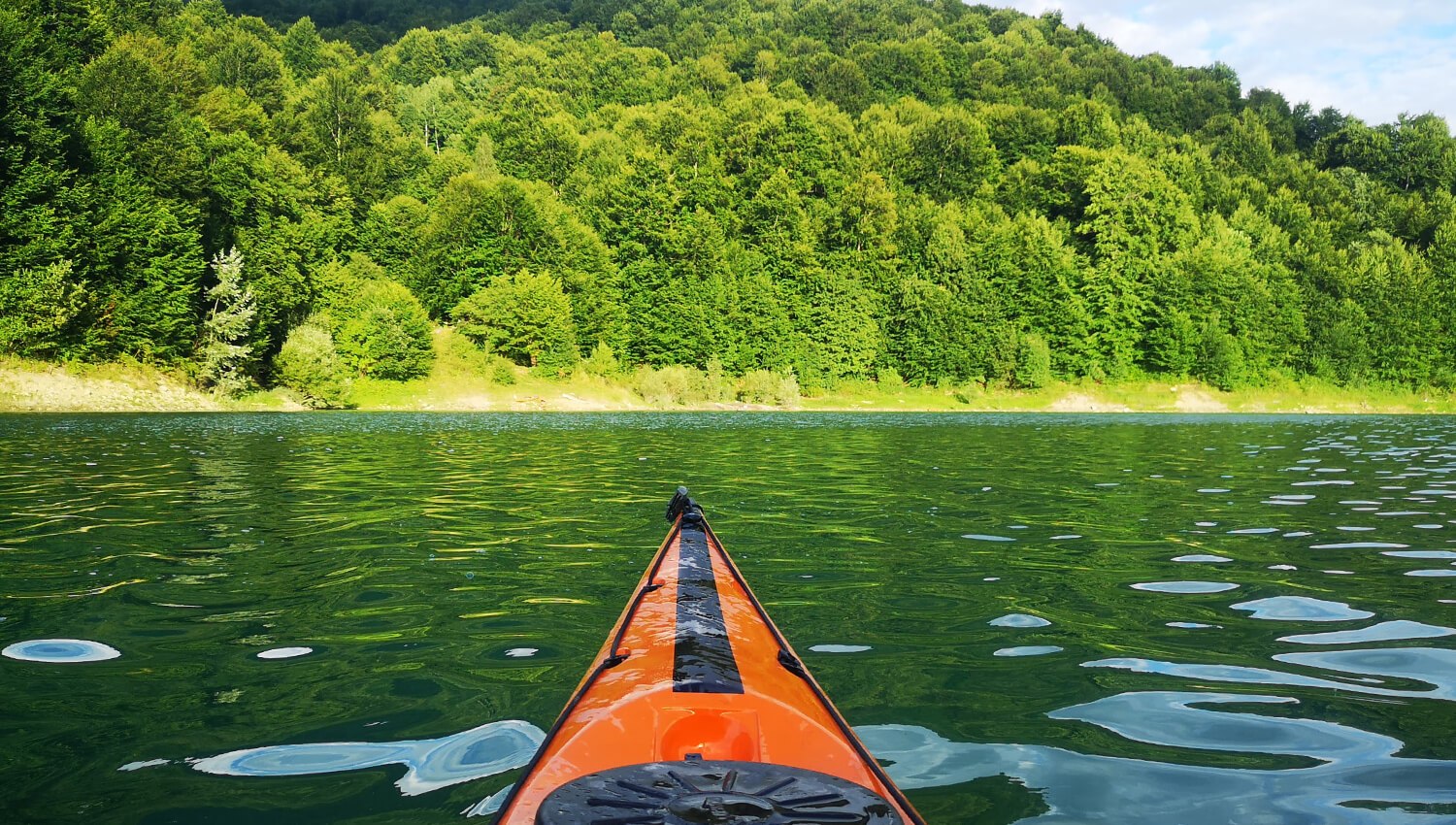 Colourful kayaks on the shore of Poiana Uzului Lake