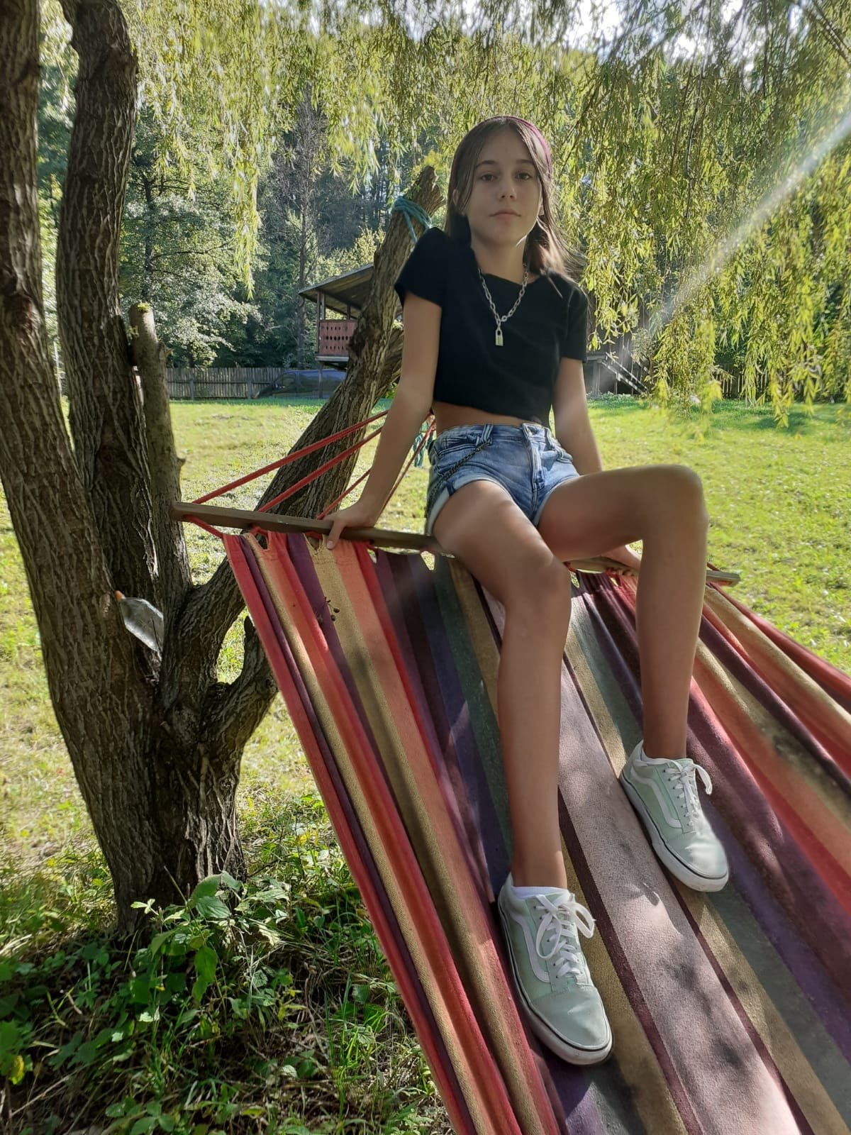 Child in the hammock under the willow in the guesthouse yard